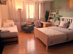 ein Schlafzimmer mit einem Bett, einem Sofa und einem Stuhl in der Unterkunft Studio avec wifi a Paris in Paris
