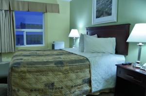 a bedroom with a large bed and a window at Nova Inn Inuvik in Inuvik