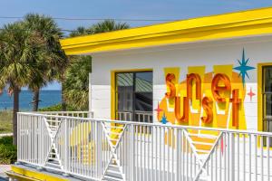 a yellow and white house with a sign on it at Sunset Inn and Cabanas in St. Pete Beach