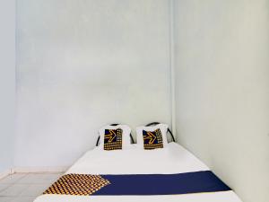 uma cama num quarto com duas almofadas em SPOT ON 91834 Sg 99 Homestay Syariah em Parit
