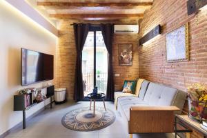 ein Wohnzimmer mit Sofa und Ziegelwand in der Unterkunft AG Apartments in Barcelona