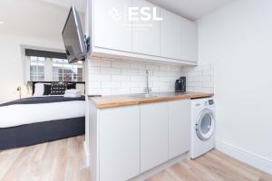 ein Schlafzimmer mit einem Bett und einem Waschbecken und einer Waschmaschine in der Unterkunft Studio 3, Top Floor Town Centre Apartment in Shrewsbury