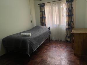 a bedroom with a bed with a towel on it at Agradable departamento - casa con estacionamiento gratis in Sucre