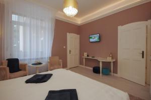 a bedroom with a bed and a table and a window at Glamour Apartman in Gyula