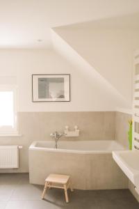 een witte badkamer met een bad en een wastafel bij Haus Hummel in Lieske