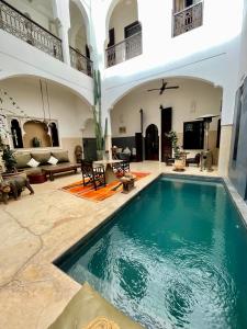 Riad Dar Massai في مراكش: مسبح داخلي في منزل مع غرفة معيشة