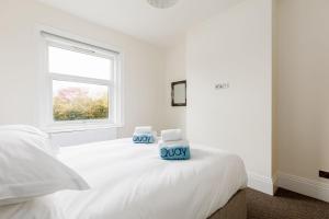 a white bedroom with a bed with two towels on it at Park Lake View in Poole