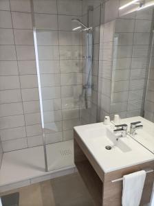 サン・テティエンヌにあるHotel ASTORIA- Saint Etienne-Centre des Congrès-の洗面台とシャワー付きのバスルーム