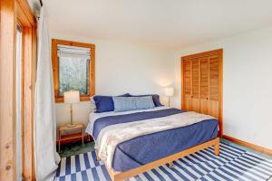 a bedroom with a bed with blue sheets and a window at Serene Jonesport Escape Deck with Water Views! in Jonesport