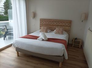 um quarto com uma cama e uma grande janela em Hotel Astoria em Saint-Étienne
