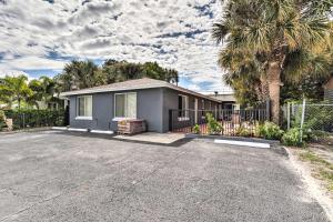 a house with a palm tree and a fence at Inviting Apartment Less Than 2 Mi to Riviera Beach! in West Palm Beach