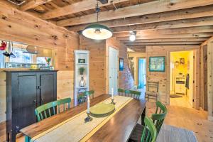 a dining room with a wooden table and green chairs at Private Sunapee Getaway 2 Mi to Ledge Pond! in Sunapee