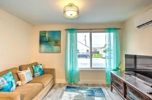 a living room with a couch and a large window at Turquoise Escape about 1 Mi to Sailfish Marina! in West Palm Beach