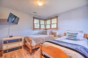 a bedroom with two beds and a tv on the wall at Chic Fox River Grove Home with Great Location! in Fox River Grove