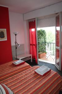 グラッソッビオにあるGuesthouse La Roccaのベッドルーム1室(ベッド2台付)、スライド式ガラスドアが備わります。
