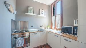 y cocina con fogones y microondas. en Stylish Renovated Apartment In The Heart Of The City, en Venecia