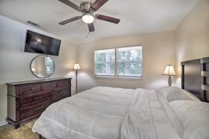 a bedroom with a bed with a ceiling fan and a mirror at Charming Tallahassee Home 1 Mi to Lake Ella! in Tallahassee