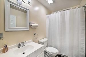 a bathroom with a sink and a toilet and a mirror at Charming Tallahassee Home 1 Mi to Lake Ella! in Tallahassee