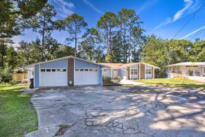 a house with a white garage and trees at Charming Tallahassee Home 1 Mi to Lake Ella! in Tallahassee