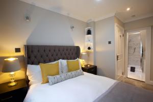 een slaapkamer met een groot wit bed met gele kussens bij Avari Apartments - Winchester Collection in Londen