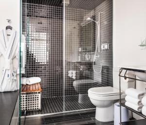 a bathroom with a toilet and a glass shower at The Standard - East Village in New York