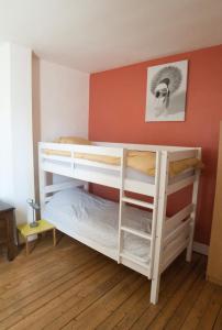 2 stapelbedden in een kamer met een rode muur bij Chez Pia in Dieppe