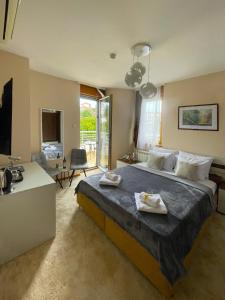 ein Schlafzimmer mit einem großen Bett mit Handtüchern darauf in der Unterkunft Freya SPA Apartments in Niš