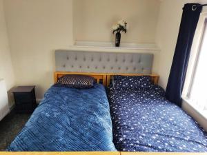 a bedroom with two beds next to a window at Cheerful 2-bedroom home with off street parking in Blackpool