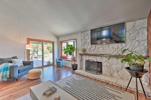 a living room with a fireplace with a tv on the wall at Modern Oceanside Home with Pool and Putting Green in Oceanside