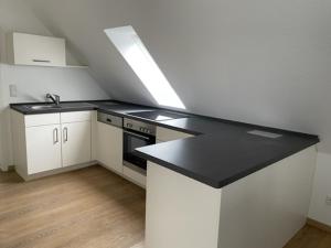 eine Küche mit einer schwarzen Arbeitsplatte in einem Raum in der Unterkunft Ferienwohnung Wilzenbergblick in Schmallenberg