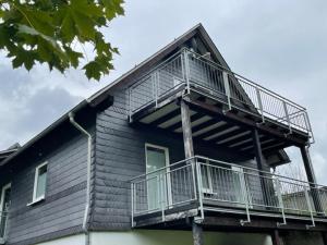 ein Gebäude mit einem Balkon an der Seite in der Unterkunft Ferienwohnung Wilzenbergblick in Schmallenberg