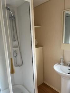 een badkamer met een douche en een wastafel bij Coyles retreat in Stranraer