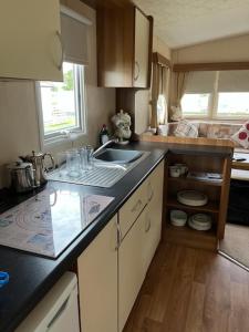 uma cozinha com um lavatório e uma bancada em Coyles retreat em Stranraer