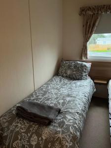 uma pequena cama num quarto com uma janela em Coyles retreat em Stranraer
