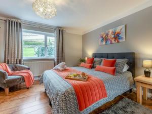 a bedroom with a bed with orange pillows at Y Lonydd in Ciliau-Aeron
