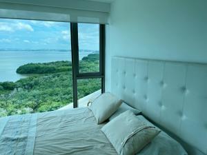 a bed in a room with a large window at Luxury Apartment in Ocean Pavillion Hotel in Cartagena de Indias