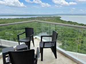 a balcony with chairs and a view of the water at Luxury Apartment in Ocean Pavillion Hotel in Cartagena de Indias
