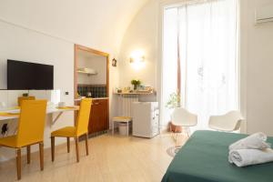 ナポリにあるTotò Style Apartmentのベッドルーム1室(ベッド1台、テーブル、椅子付)