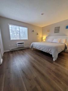 a bedroom with a large bed and a window at 2 Bdrm Condo walking distance to Weirs Beach in Laconia