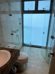 a bathroom with a toilet and a glass shower at Luxury Apartment in Ocean Pavillion Hotel in Cartagena de Indias
