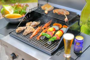 a grill with meat and vegetables and a glass of beer at First Villa in Yamanakako