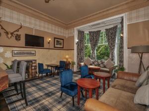 a living room filled with furniture and a fireplace at Clonyard House Hotel in Dalbeattie