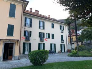 um edifício branco com persianas pretas em Villa Paola - Holiday Apartment - Menaggio, Lago di Como em Menaggio
