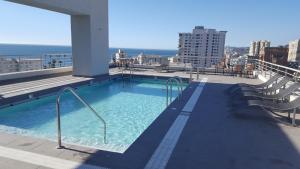 una piscina en la azotea de un edificio en Delpino Propiedades Costa Viña, en Viña del Mar
