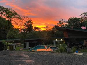 um pôr-do-sol sobre uma casa com piscina em Eco Lung Hotel em Montezuma