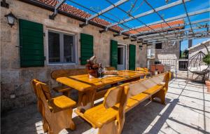 a wooden table and benches on a patio at Gorgeous Home In Slivno With Sauna in Slivno
