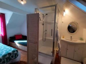 a bathroom with a shower and a sink and a bed at La P'tite Normande in Villerville +51 photos