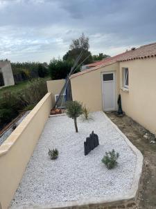 un patio trasero con un pequeño patio con una casa en Loft atlantique Rochefort, en Rochefort