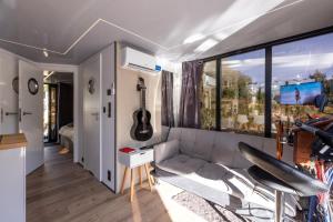 a living room with a couch and a guitar at La Mare Boathouse, Tallinn in Tallinn