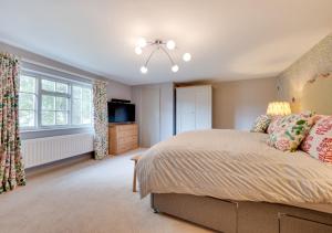 a bedroom with a bed and a television in it at 6 North Green in Southwold